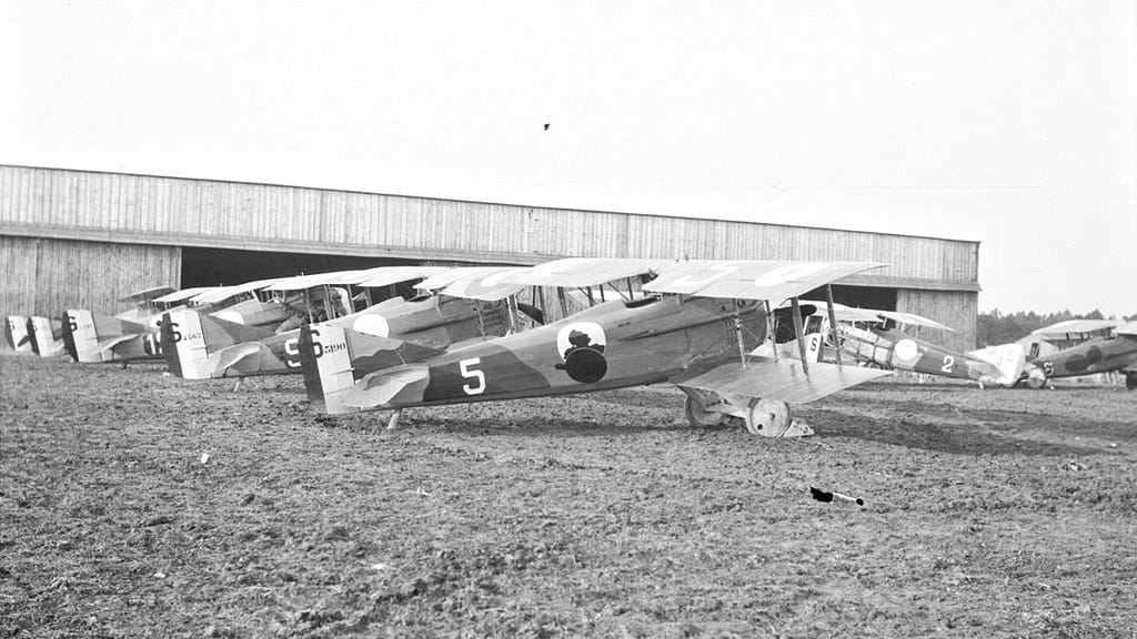 Rangée d'avions de chasse Spad alignés devant un hangar sur un aérodrome français en 1918 — prêtres aviateurs 1914-1918