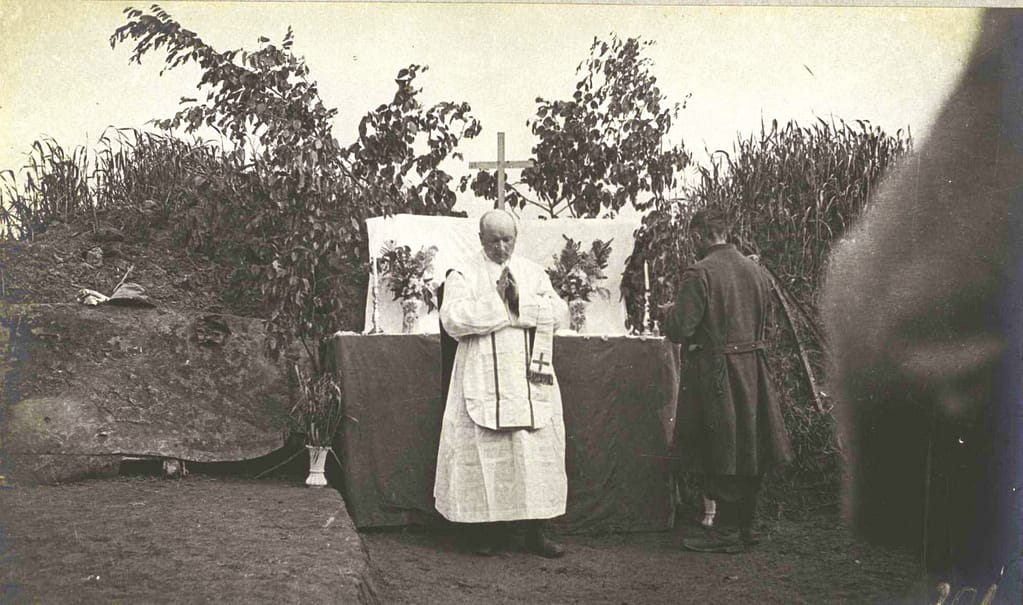 Aumônier Grande Guerre célébrant la messe en première ligne aux Ouvrages Blancs près de Bellacourt en 1915, soldat agenouillé et troupe en uniforme assistant à l'office