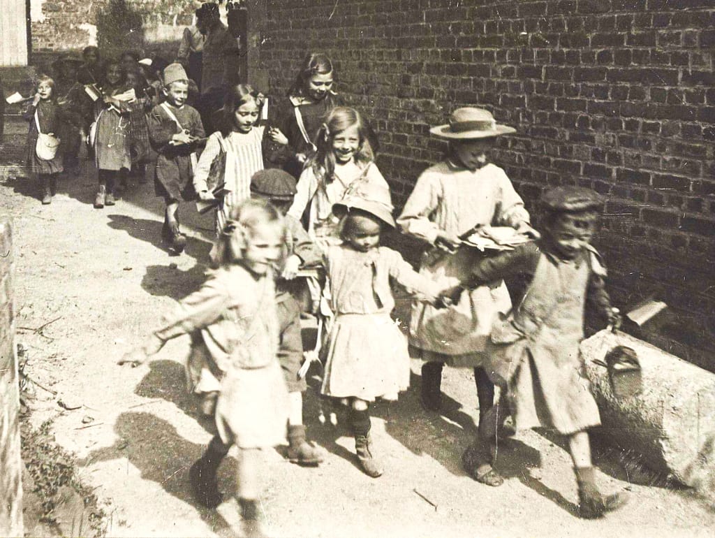 Sortie d'école sous occupation dans le Nord de la France, enfants avec leurs affaires, 1914-1918
