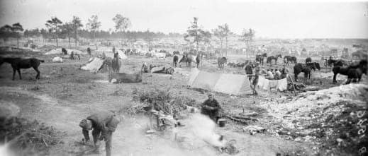 Cantonnement du 8e régiment de marche de zouaves aux abris Saint-Roch près de Suippes (Marne), avec chevaux, tentes et soldats au repos. Bacheré était aumônier de ce régiment.