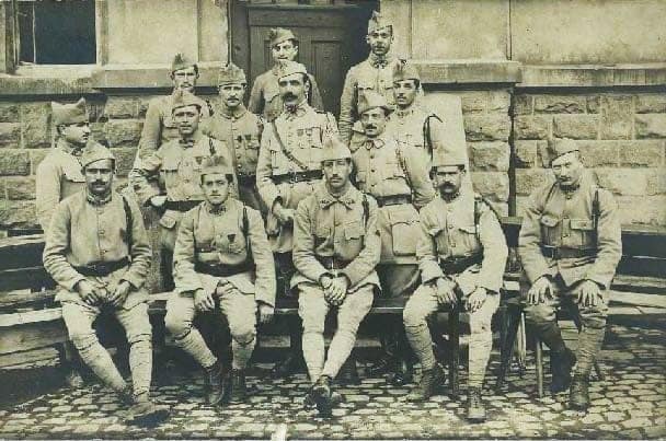 Photographie de groupe d'hommes du 162e Régiment d'Infanterie, vraisemblablement 1917-1918, dont plusieurs portent les insignes des blessés sur leur vareuse.